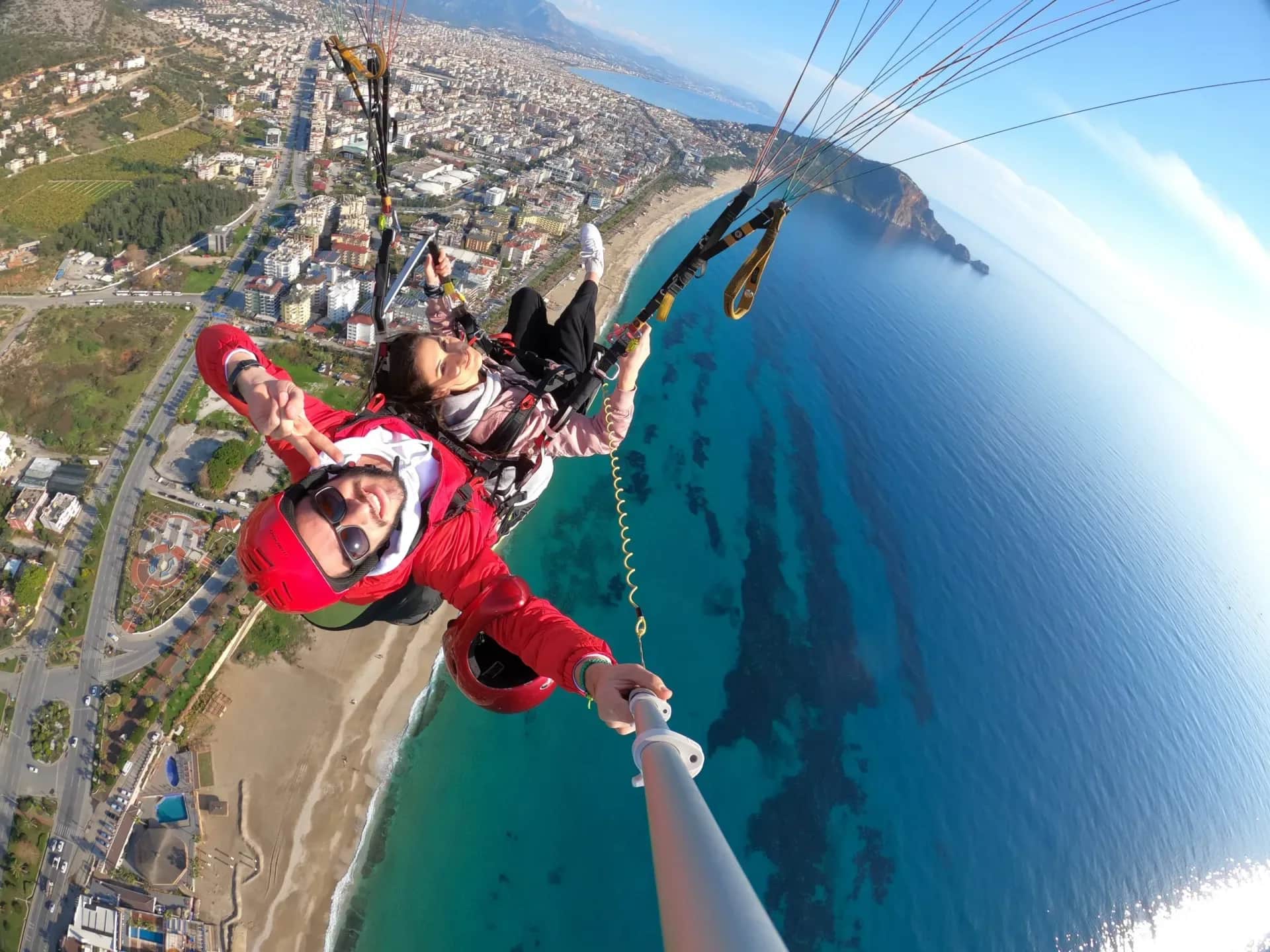 Alanya'da denizin üzerinde tandem uçuşta pilot ve yolcu