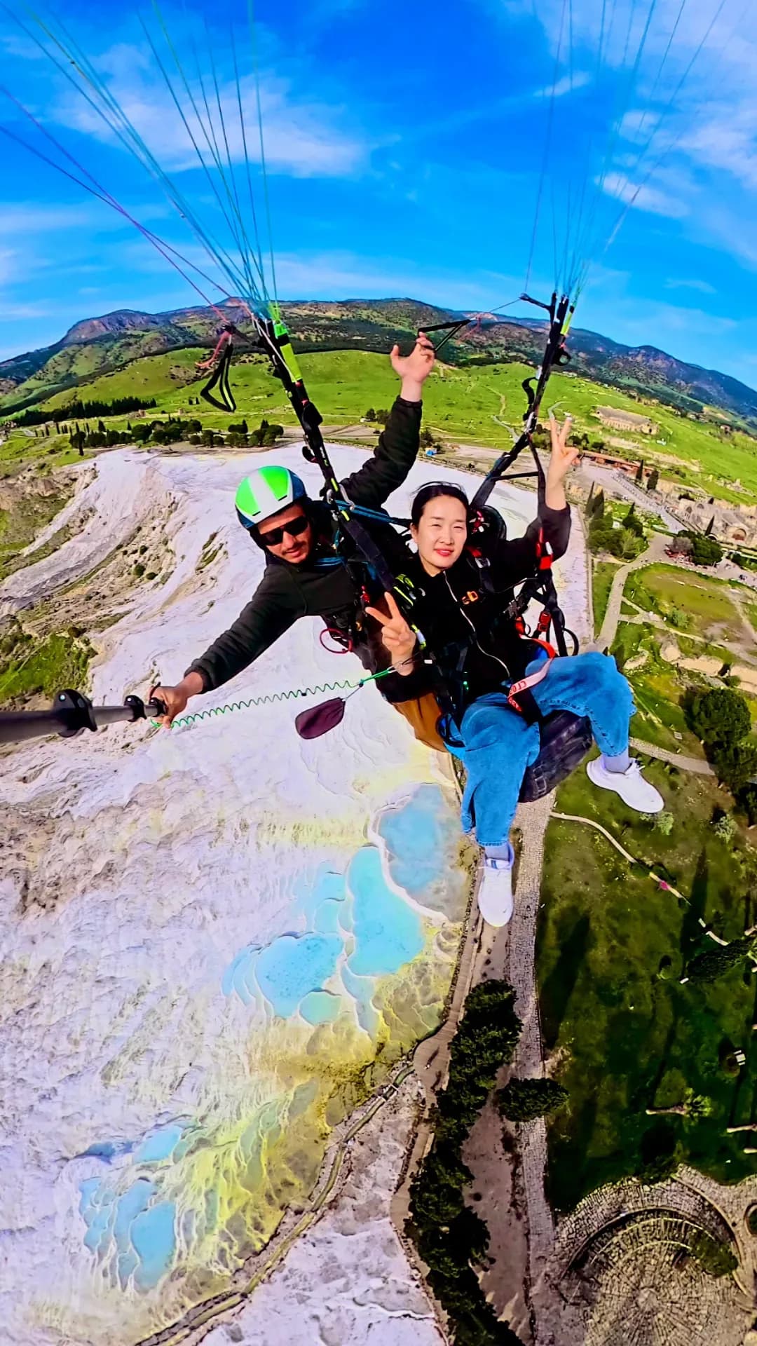 Pamukkale travertenleri ve yeşil tepeler üzerinde tandem pilot ve yolcu