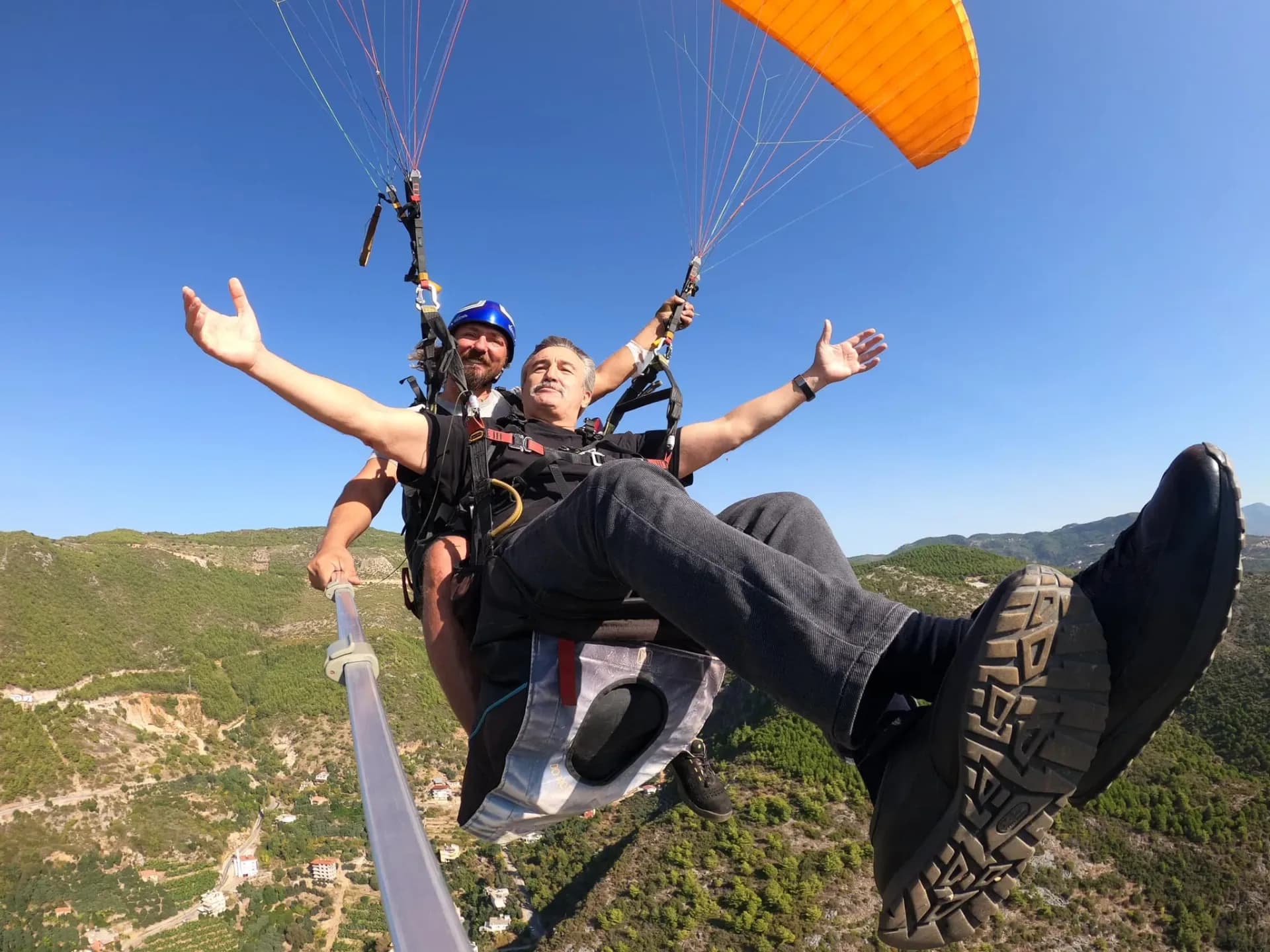 Pilot and passenger spreading their arms on a tandem flight